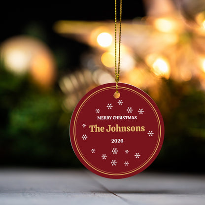 Personalized family name Christmas ornament with warm holiday lights behind it
