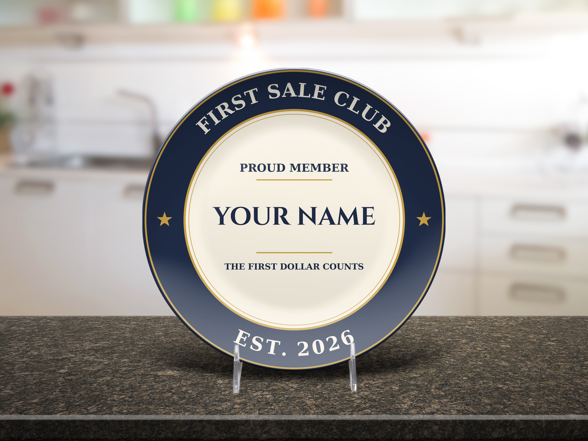 Personalized First Sale Club plate in navy, cream and gold reading Proud Member, Your Name, The First Dollar Counts, Est. 2026, on a granite kitchen counter