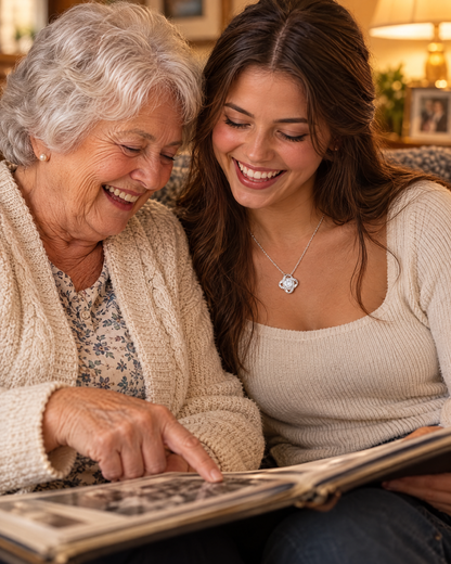 Grandmother and granddaughter looking at a photo album; granddaughter wears the Love Knot necklace