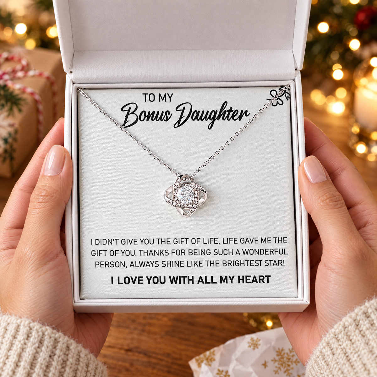 Gift box with the Love Knot necklace and its printed message card, held in two hands