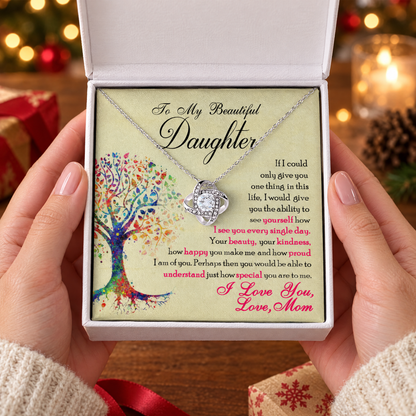 Gift box with the Love Knot necklace and its printed message card, held in two hands