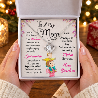 Gift box with the Love Knot necklace and its printed message card, held in two hands
