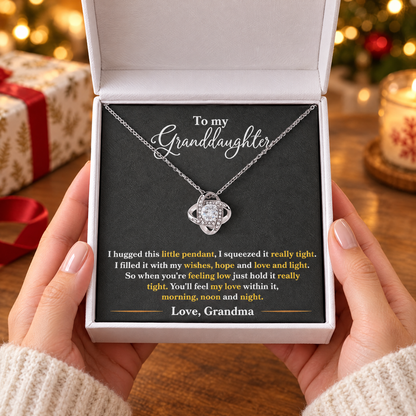 Gift box with the Love Knot necklace and its printed message card, held in two hands