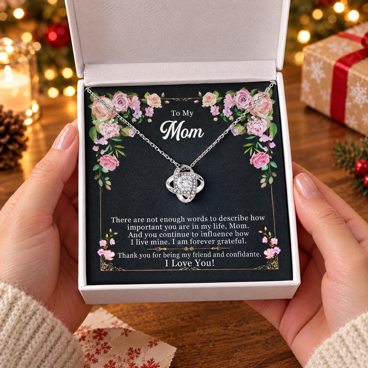 Gift box with the Love Knot necklace and its printed message card, held in two hands
