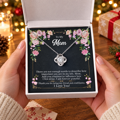 Gift box with the Love Knot necklace and its printed message card, held in two hands